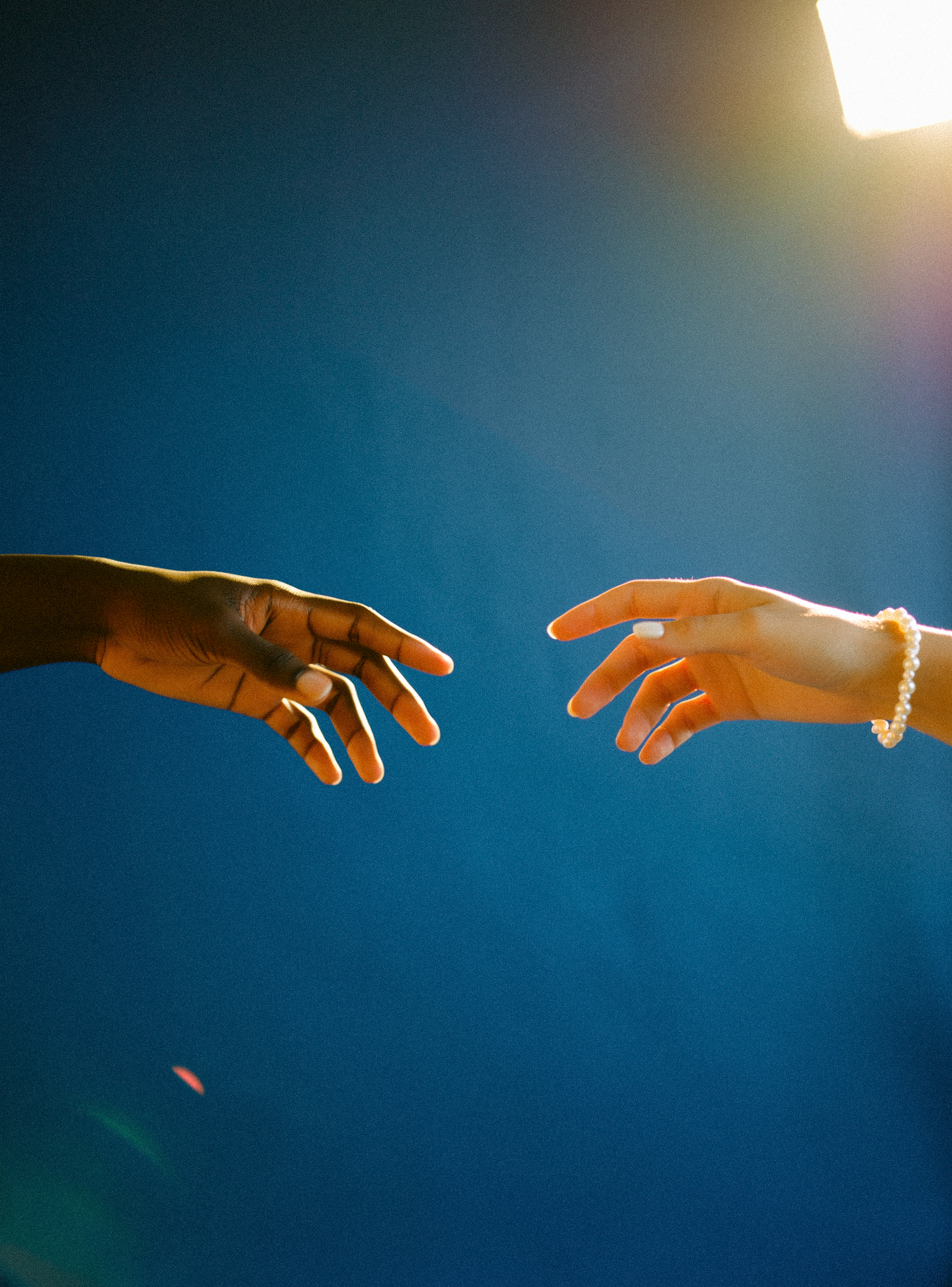 Two hands reaching toward each other, symbolizing unity, human rights, and the importance of speaking out against injustice, ICE policies, and authoritarian government actions.